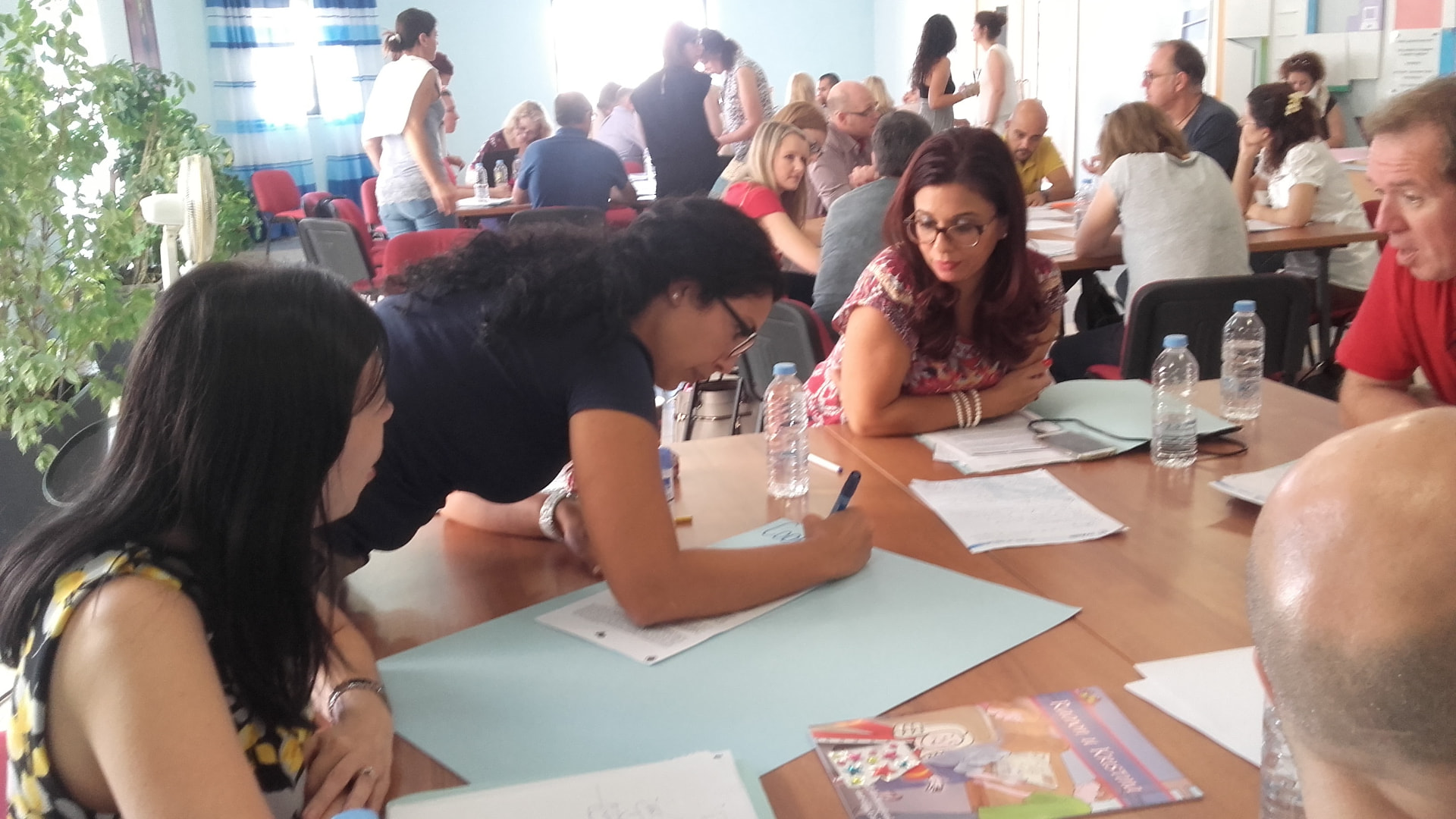 Adult learners collaborating around a table during a structured Erasmus+ training workshop